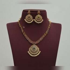 Elegant gold replica necklace set with intricate kundan work, green stones, and pearl embellishments, paired with matching statement earrings, perfect for weddings and festive occasions.