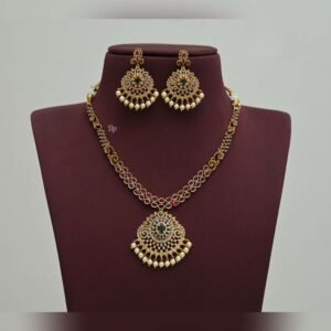 Elegant gold replica necklace set with intricate kundan work, green stones, and pearl embellishments, paired with matching statement earrings, perfect for weddings and festive occasions.