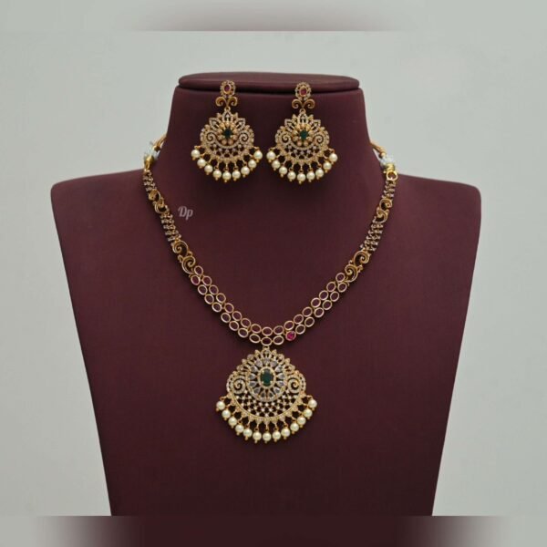 Elegant gold replica necklace set with intricate kundan work, green stones, and pearl embellishments, paired with matching statement earrings, perfect for weddings and festive occasions.