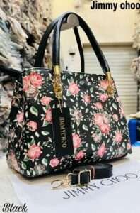 Stylish black handbag adorned with vibrant flower patterns, offering a chic and versatile look for both casual and formal occasions.
