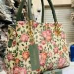 Charming cream handbag embellished with intricate floral designs, blending elegance and functionality for everyday use.