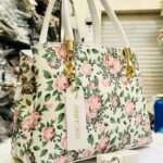 Elegant white handbag featuring a delicate flower design, crafted with premium materials, perfect for adding a touch of sophistication to any outfit.