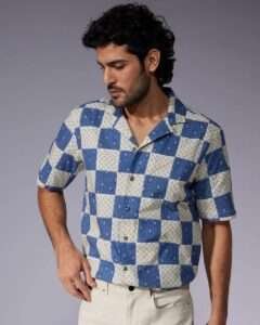 Man wearing a trendy cotton printed shirt with half sleeves, styled casually with jeans for a perfect summer look.