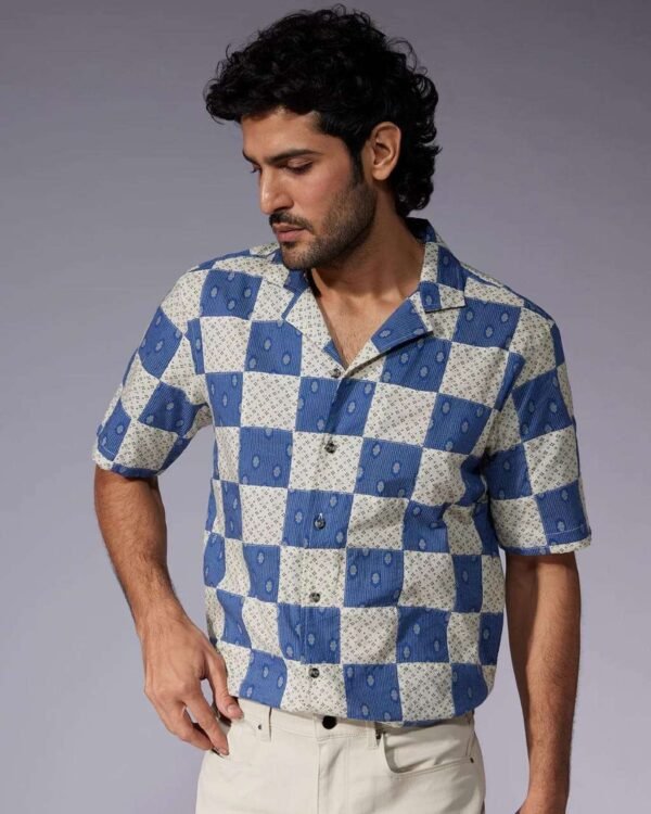 Man wearing a trendy cotton printed shirt with half sleeves, styled casually with jeans for a perfect summer look.